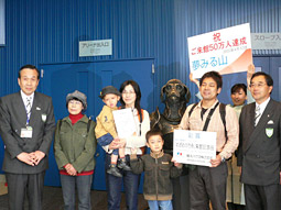 記念品贈呈後、神谷達（とおる）館長、安東三男副館長と記念写真を撮る真弓さん一家の画像