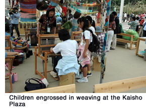 Children engrossed in weaving at the Kaisho Plaza