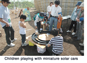 Children playing with miniature solar cars